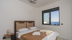 Un dormitorio con cama, ventana, mesita de noche y cabecero.