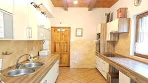 Uma cozinha com armários de madeira, uma pia dupla, um fogão e uma janela.