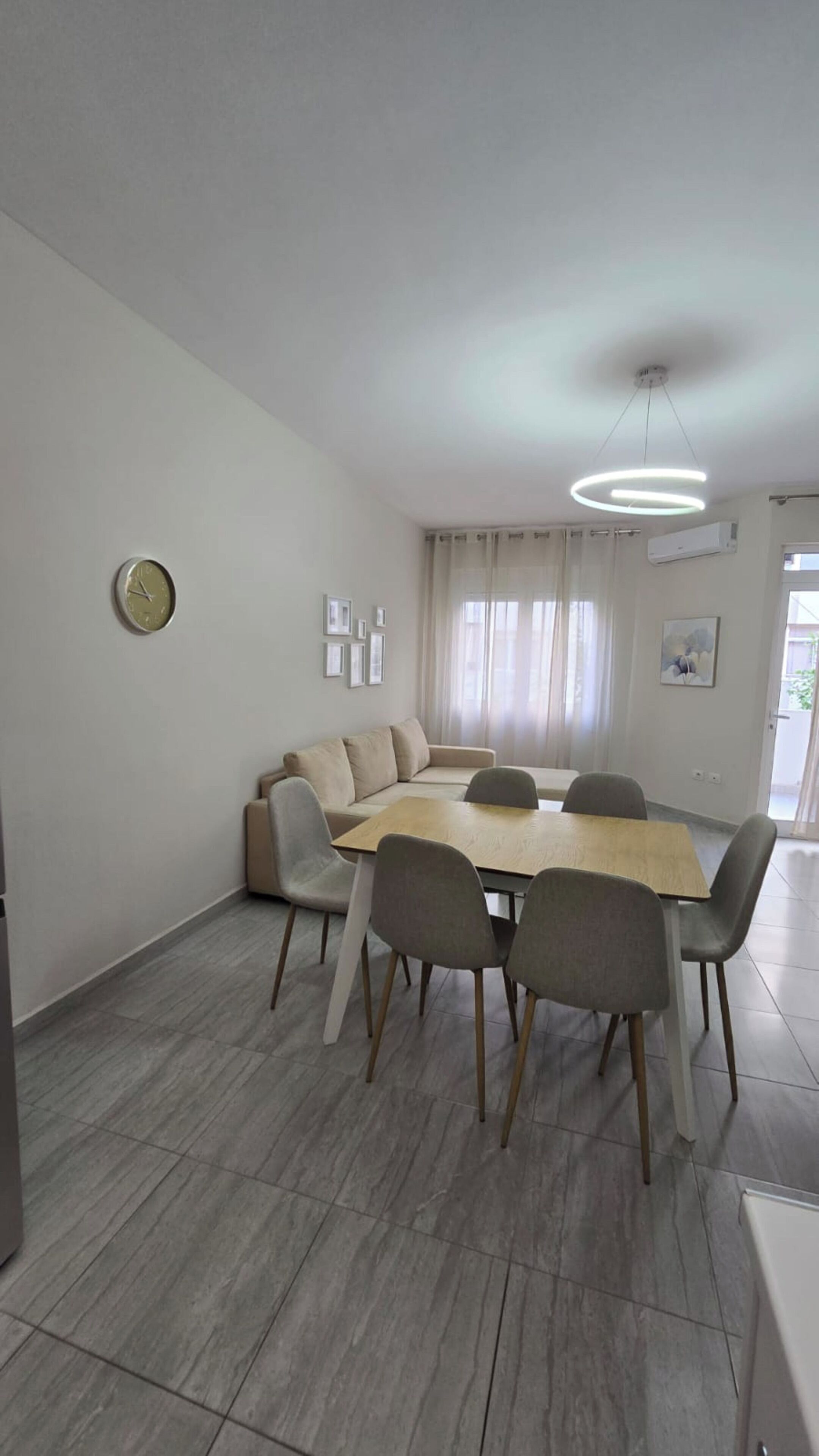 Una sala de estar moderna con una mesa de comedor, un sofá y sillas.