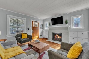 A living room with a fireplace, a television, and a sofa.
