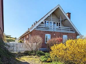 A red brick house with a gabled roof and a wooden porch. - 6 Person Holiday Home in Logstrup (Logstrup)