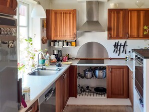 A compact kitchen with wooden cabinets, a stainless steel range hood, and a built-in oven. - 6 Person Holiday Home in Logstrup (Logstrup)