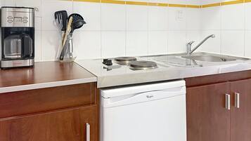 Una cocina con cafetera, lavabo y lavavajillas.