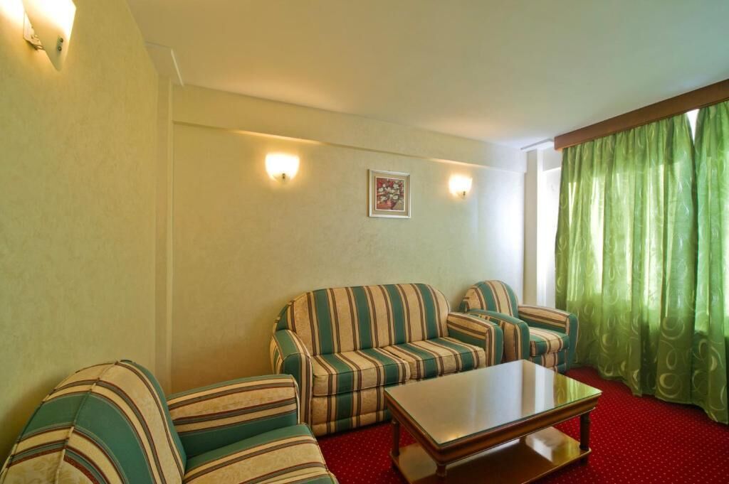 A room with striped sofas, a wooden coffee table, and a framed picture on the wall.