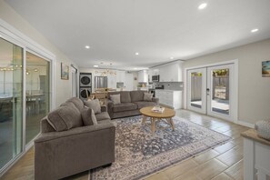 A modern living room with a sofa, a coffee table, and a rug. - The Sea Salt Grand Suite: Modern Siesta Charm (Siesta Key)