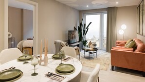 Ein modernes Wohnzimmer mit Essbereich, einer Couch und einem Fernseher.