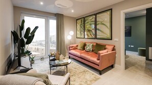 Ein modernes Wohnzimmer mit einer Ledersofa, einem Couchtisch und einem großen Fenster.