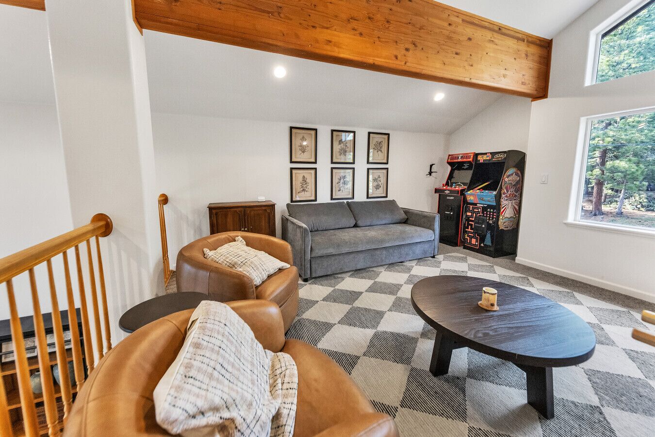 Una sala de estar con sofá, sillones, una mesa de centro, chimenea y consola de videojuegos.