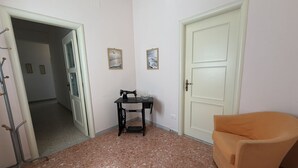 A room with a sewing machine, a chair, and a door. - Kairos - Casa Vacanze (Fuscaldo)