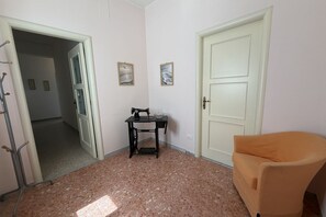Una habitación con una máquina de coser, una silla y una puerta.