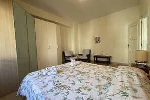 A bedroom with a bed, two chairs, a small table, and a wardrobe. - Kairos - Casa Vacanze (Fuscaldo)