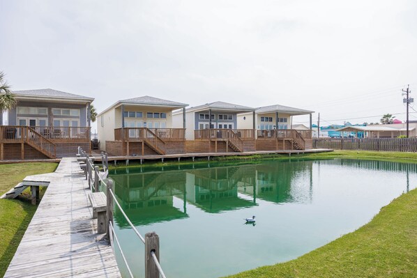 Eine Reihe von Ferienhäusern am Wasser mit Holzdecks und ruhiger Wasserfläche.