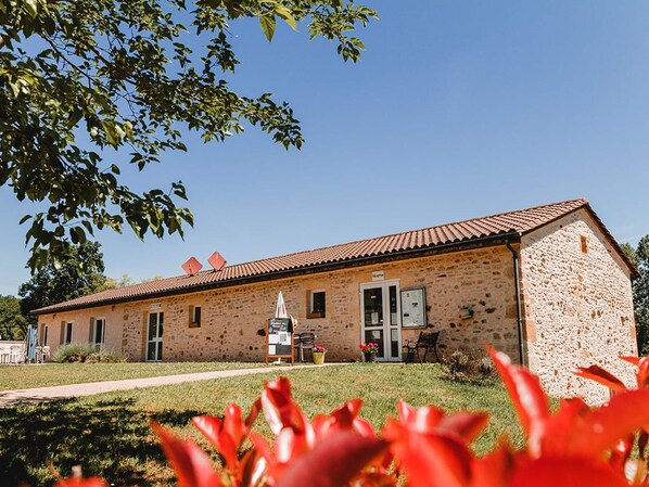 A stone building with a tiled roof, a door, and a small signboard. - Accessible Family Cottage in Marminiac (Marminiac)