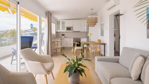 A modern apartment with a balcony, a kitchen, and a living area. - Sunsuites Collection - Las Flores (San Bartolome de Tirajana)