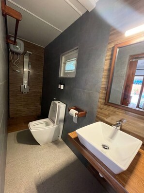 Casa de banho com sanita, bidé e lavatório.