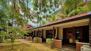 A building with a covered walkway, potted plants, and a brick facade.
