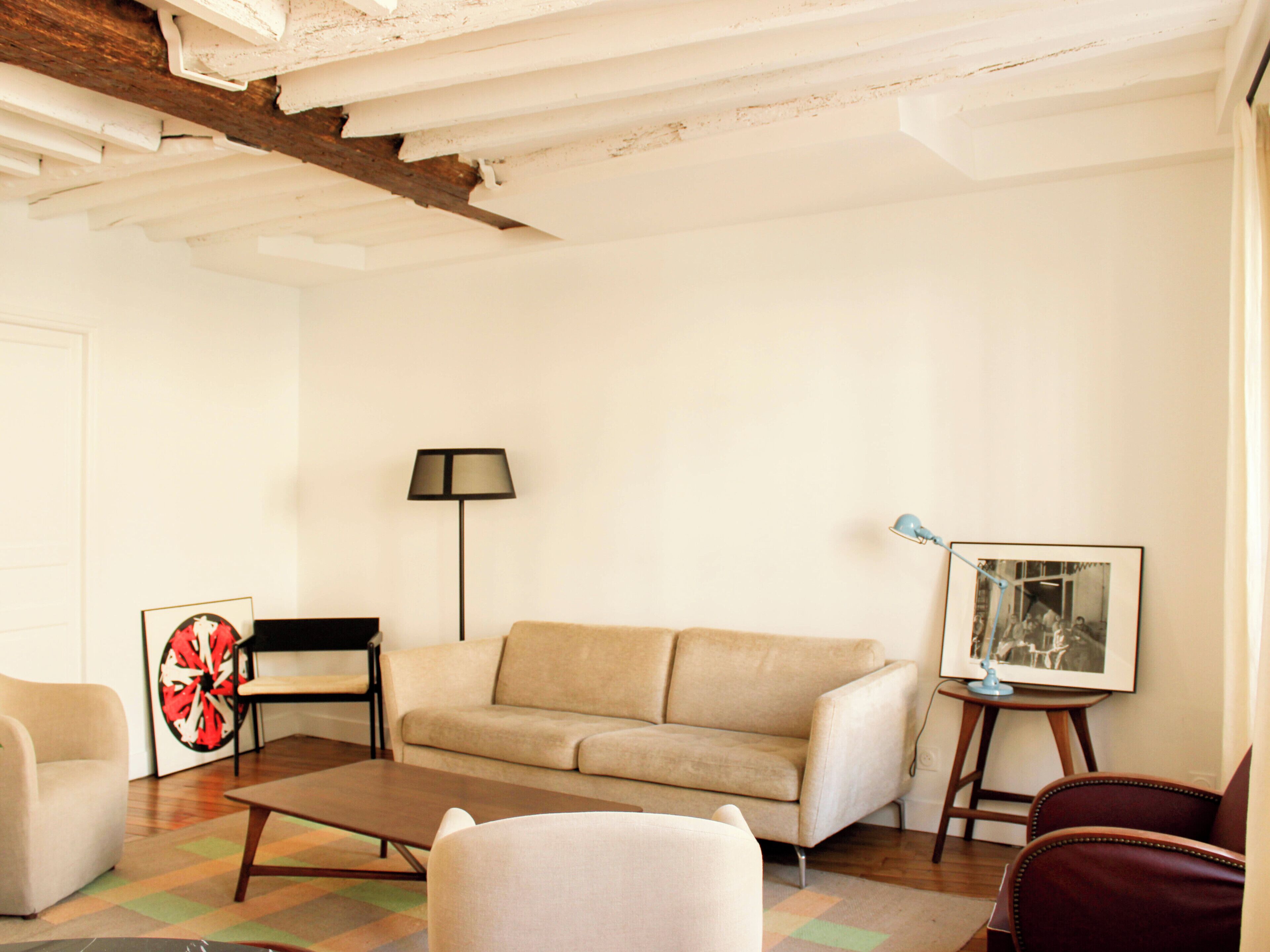 A living room with a sofa, a coffee table, a lamp, and a chair.
