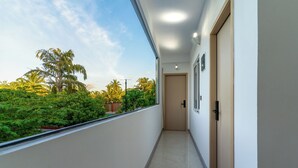 A corridor with a view of greenery and a door at the end. - Ocean Bounty (Ukulhas)
