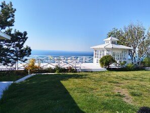 A white gazebo with a clear view of the ocean, surrounded by a white fence and greenery. - Charming 3-bedroom house in gorgeous Balchik with AC and gym (Balchik)