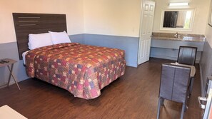 A bedroom with a bed, bedside table, and a chair.