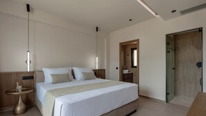 Camera d'albergo moderna con un letto grande, comodini, una porta in legno e un divisorio in vetro.