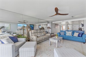 Ein modernes Wohnzimmer mit einer Couch, einem Sessel und einem blauen Sofa.