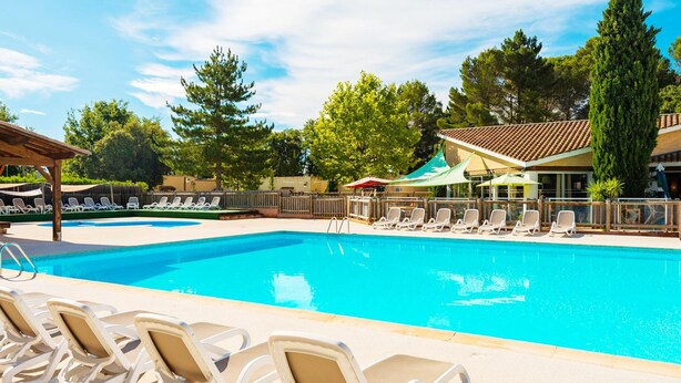 A swimming pool with lounge chairs and a covered area. - Charming Countryside Maisonette (Les Mathes)