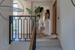 A staircase with a modern railing, a large plant, and a wooden door. - Azur BlueSky luxury villa , great views near the beach (Bali)