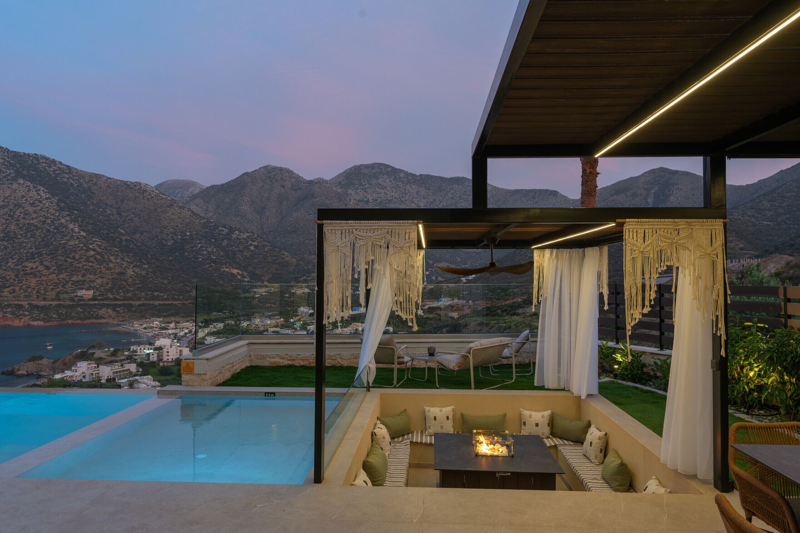 Un salon de bord de piscine offrant une vue sur les montagnes et un plan d’eau.