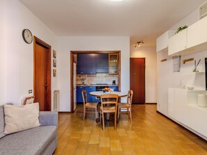 Un espace de vie compact comprenant un coin repas, une kitchenette et un canapé.