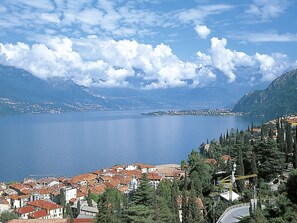 A coastal town with red-roofed buildings, a clear blue lake, and mountains in the background. - Casa Elena by Interhome (Bellano)