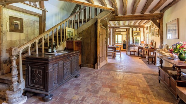 A rustic interior with exposed wooden beams, a wooden staircase, a dining area with a table and chairs, and a large wooden cabinet. - La Bécassière | Family Normandy house with pool & nature (Genneville)