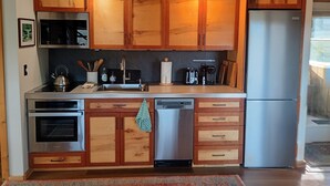 A kitchen with wooden cabinets, stainless steel appliances, and a built-in dishwasher.