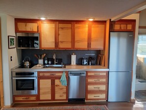 A kitchen with wooden cabinets, stainless steel appliances, and a built-in dishwasher.