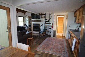 Un intérieur chaleureux comprenant un espace de vie, une cuisine et un escalier en colimaçon.