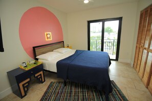 A bedroom with a bed, a nightstand, a colorful rug, a balcony with a view, and a unique pink wall design. - Miami Havana Nights -Parking, Close to Brickell, LoanDepot (Miami)