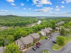 A hotel with multiple buildings, a parking lot, and a river in the background. - The View on Overlook Balcony (Branson)