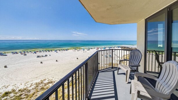 Un balcon avec vue sur une plage et l’océan.