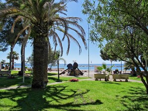 A park with palm trees, benches, and a view of the sea. - il Forno by Interhome (San Bartolomeo al Mare)