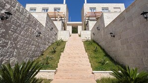 A staircase leading to a building with stone walls and a clear blue sky. - Becici Hills Adriatic Villas (Bečići)