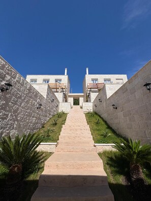 A staircase leading to a building with stone walls and a clear blue sky.