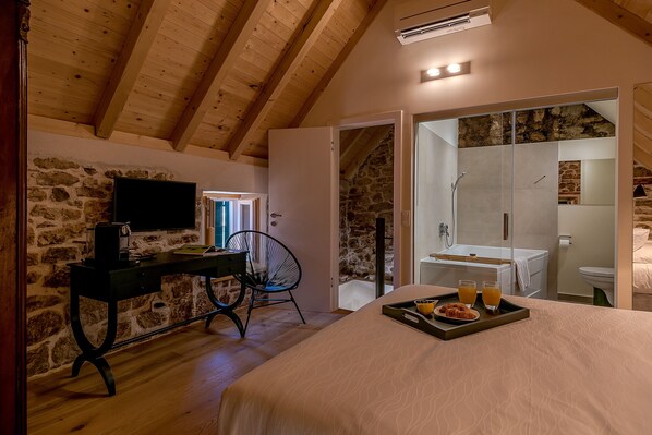 A bedroom with a bed, a desk, a chair, a television, and a breakfast tray. - Suite in the heart of the town, few steps from the sea (Kaštel Stari)