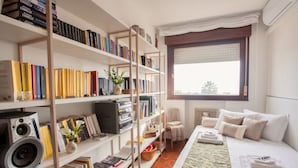 A neatly organized room with a bed, a bookshelf, a desk with a computer, and a window with a view. - Casa Macor (Venice)