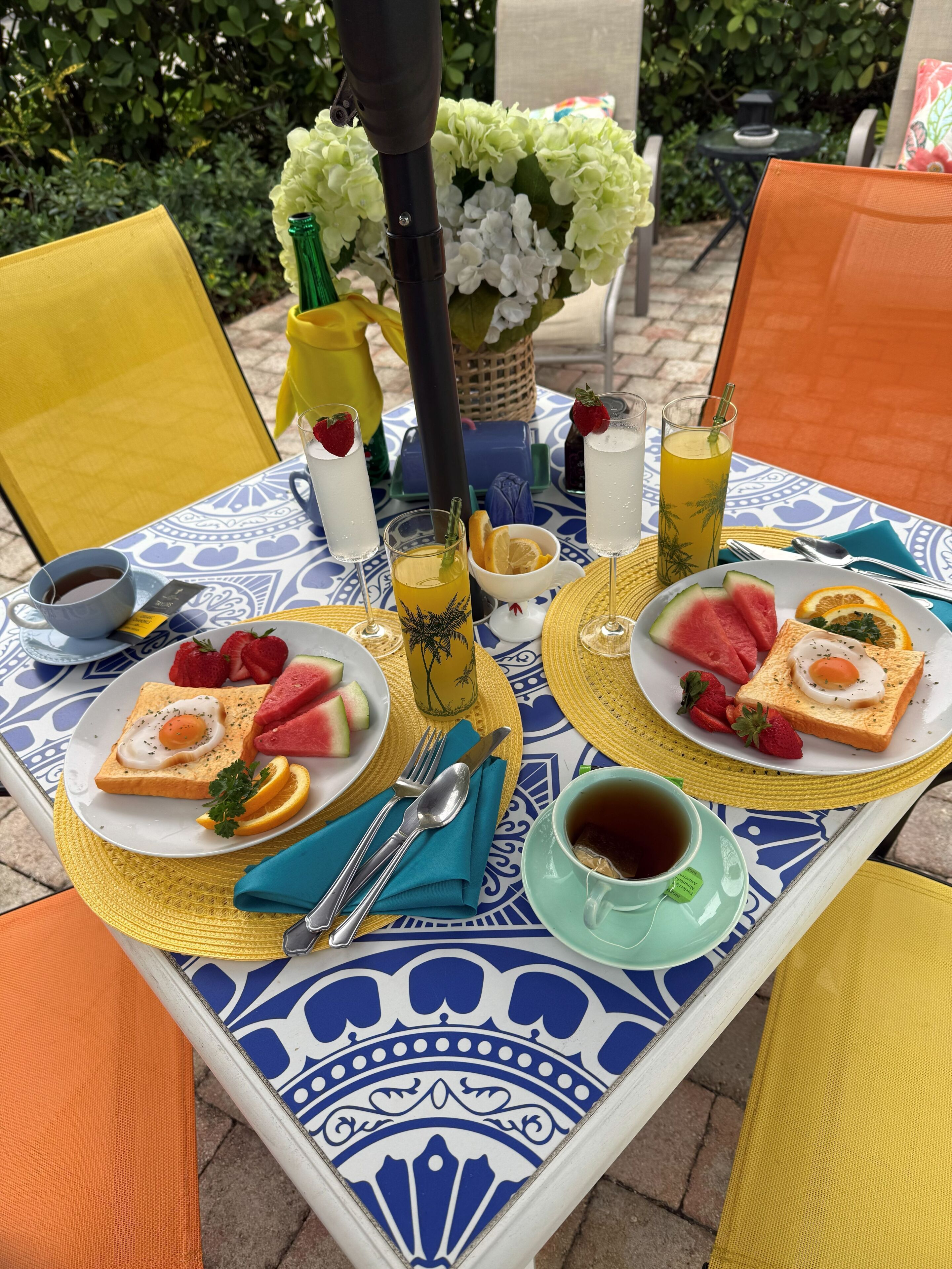 A table set with breakfast items, including toast, eggs, strawberries, watermelon, and juice.