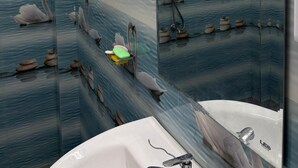 Un baño con cabina de ducha de vidrio, un lavabo y un espejo que refleja cisnes y piedras.