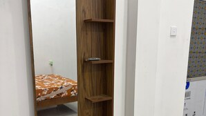 Una cómoda de madera con espejo, un cajón y un estante.