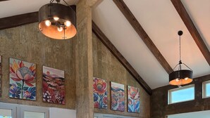 A spacious living area with leather sofas, a coffee table, and artwork on the walls. - Beachfront, Luxury Oasis with Private Resort Pool (Palmer)