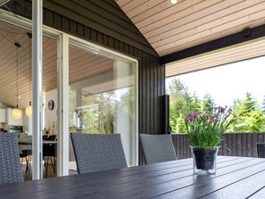 Eine Terrasse im Freien mit Tisch, Stühlen und einem Blumentopf.