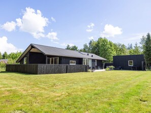 Ein modernes, zweistöckiges Haus mit großem Vorgarten und separater Garage.