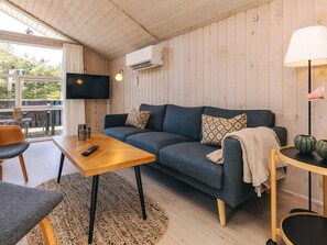 Un salon confortable avec un canapé, une table basse et un téléviseur.